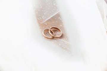 wedding rings lie on a Lacy shiny fabric