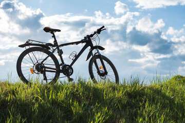 Mountain bike stands on the grass with blue sky in the background