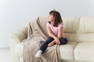 Obraz premium Cute girl kid with cat ears sitting on the couch. Children and childhood concept.