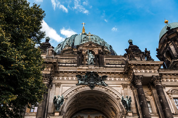 Beautiful cityscape with Berliner Dom against blue sky in summer. Bottom view of Berlin cathedral and green trees © Ludmila Denisenko