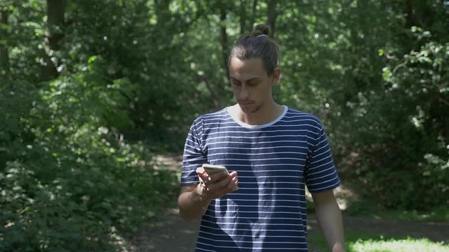 Handsome male reacting negatively towards a text message on his mobile phone 