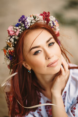 Young redhead moldavian girl, 
with a floral wreath on head,looking in the camera,close portrait.