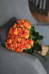 Bouquet of orange roses on a armchair 
