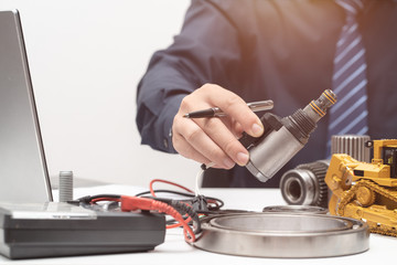 Professional engineer reaching hand to solenoid valve for during working day in office, repair maintenance heavy machinery concept