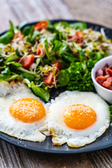 Continental breakfast - sunny side up eggs, bacon and vegetable salad