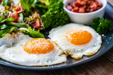Continental breakfast - sunny side up eggs, bacon and vegetable salad
