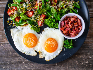 Continental breakfast - sunny side up eggs, bacon and vegetable salad