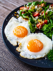 Continental breakfast - sunny side up eggs, bacon and vegetable salad