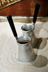 Black turkish coffee on hot sand