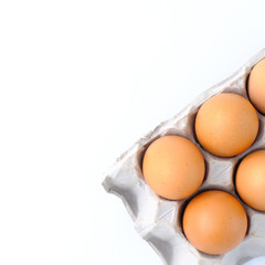 Close-up top view of organic raw eggs on white background with copy space for your text, healthy eating concept.