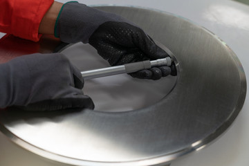 Instrument technician measuring orifice plate of gas flow measurement element by using micro meter.