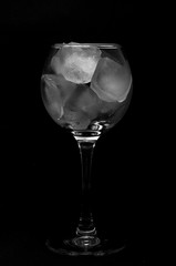Glass with ice on a black background.
