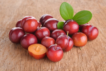 Bright red plums on old wood background
