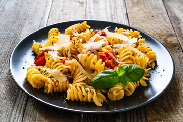 Pasta with parmesan and vegetables on wooden background