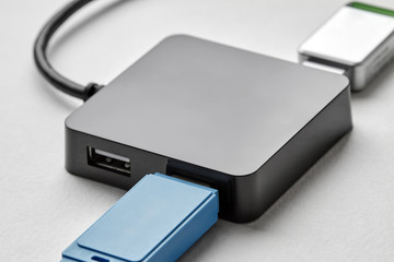 Black portable USB hub for four connections with usb flash drives on a white background. Bus povered. Closeup, selective focus