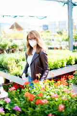  Mature woman buying plants while wearing face mask in the garden store