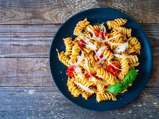 Pasta with parmesan and vegetables on wooden background