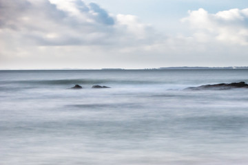 Fototapeta na wymiar Paysage de mer et vague cotoneuse à Locmariaquer (Morbihan) en pose longue