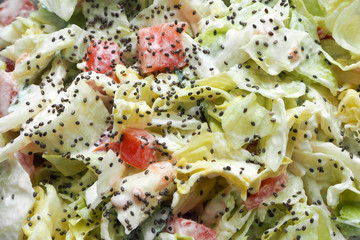 salad dressed with yogurt from onions tomatoes cucumbers iceberg lettuce sprinkled with Chia seeds . vegetable salad gluten free