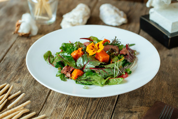 Side view on gourmet salmon and beef meat salad