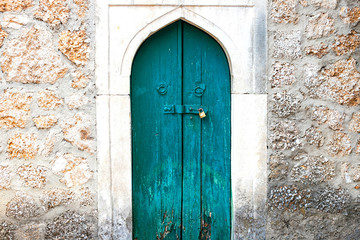 Authentic old door in Arabic style in a stone wall, in minimal style, bright colors, background.