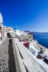 Panorama of Saint Nikolaos Peramataris orthodox church (blue dome) and view of the caldera, aegean...