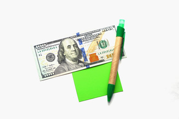One hundred dollars, pen and note paper shot together