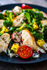 Caesar salad - fried chicken breast and vegetables on wooden table
