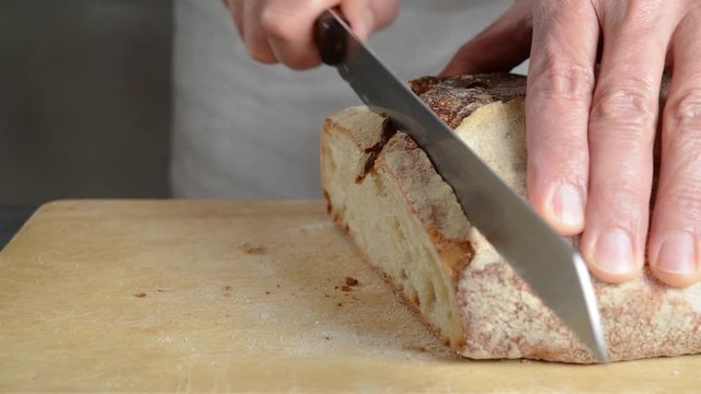 Chef cutting organic sourdough bread with type 0 wheat flour.