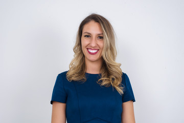 Fototapeta premium Horizontal portrait of pleasant-looking Caucasian female with long beautiful hair wearing brown sweater covering her face with hair looking happily to the camera.