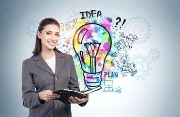 Smiling woman with notebook and her business idea