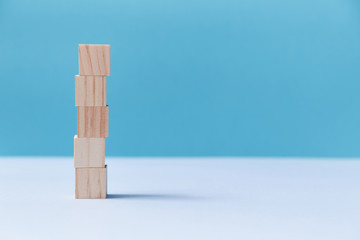 Stack of wooden cubes mockup style, copy space. Pile of blank blocks. Template for creative design on blue background
