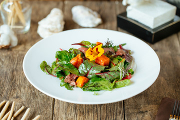 Side view on gourmet salmon and beef meat salad 