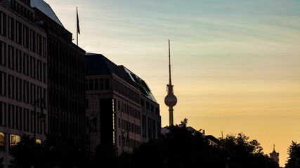 Photo of a building during sunset with a tower in the background.
