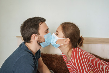 young couple in protection masks kissing each other, young woman and man kiss during epidemic
