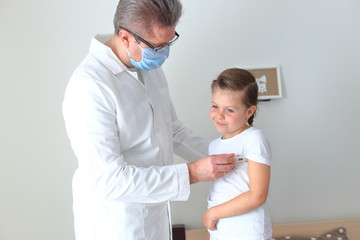 Doctor examining a little girl at home