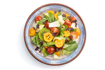 Vegetarian salad of pac choi cabbage, kiwi, tomatoes, kumquat, microgreen sprouts isolated on white background. Top view, close up.
