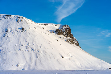 Iceland snow covered mountains with blue sky.