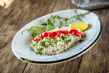 White salad with red caviar tobiko and green onion