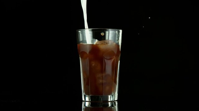 Super slow motion of pouring ice coffee into glass. Filmed on high speed cinema camera, 1000fps.