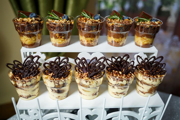 Beautifully decorated sweet buffet table on which cakes, muffins, marshmallows, pecans. Dessert table for a party, goodies for the wedding. Close up. Candy bar. A buffet for a wedding