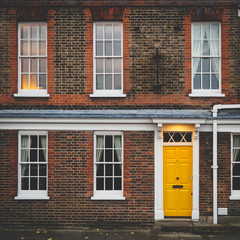 Fototapeta na wymiar Yellow door of a terrace Georgian house in London (UK).