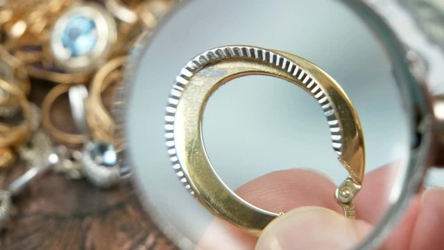 jeweler looking at jewelry through magnifying glass, jewerly inspect and verify, pawnshop concept, jewerly shop concept