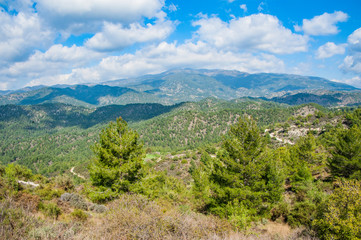 Fototapeta premium Light clouds cast fancy shadows on the peaks and slopes of the Troodos Mountains. Shadows creep from mountain to mountain, changing their shape. 