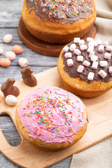 Homemade glazed and decorated easter pies on a gray wooden background and linen textile. Side view, copy space.