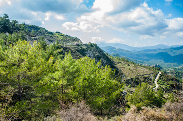 Fototapeta na wymiar Light clouds cast fancy shadows on the peaks and slopes of the Troodos Mountains. Shadows creep from mountain to mountain, changing their shape. 