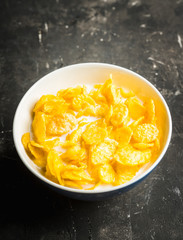 Tasty crispy corn flakes with milk in bowl on the rustic background. Selective focus. Shallow depth of field.