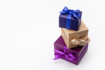 A set of vertical gift boxes in fun packaging, decorated with ribbons with bows. On white background, copy space.