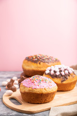 Homemade glazed and decorated easter pies on a gray wooden background and linen textile. Side view, selective focus, copy space.