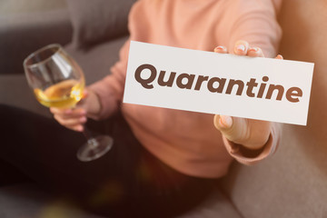 in female hands the inscription remain covert 19. coronavirus pandemic concept.in the hands of a glass of white wine